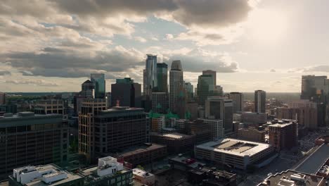 orbiting drone shot of the minneapolis skyline with sun peaking through the background late in the day