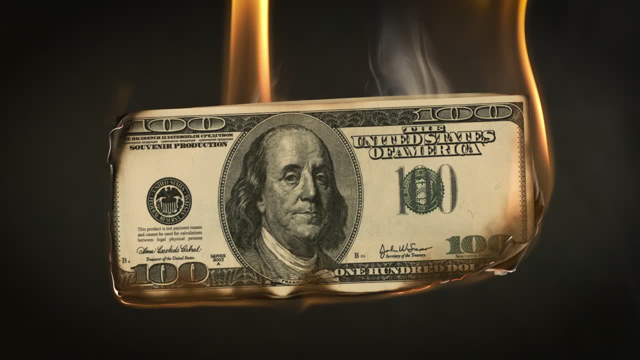 Banconota da un dollaro in fiamme su sfondo scuro