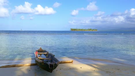 small boat or canoe on beach of secluded island in caribbean