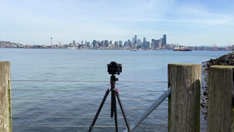 camera on tripod at luna park viewpoint in seattle, washington with cityscape view across elliott bay