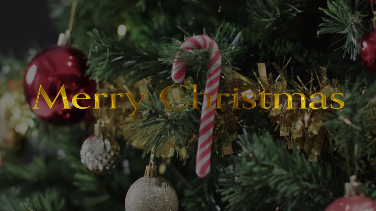 texto de feliz navidad en amarillo sobre las decoraciones en el árbol de navidad