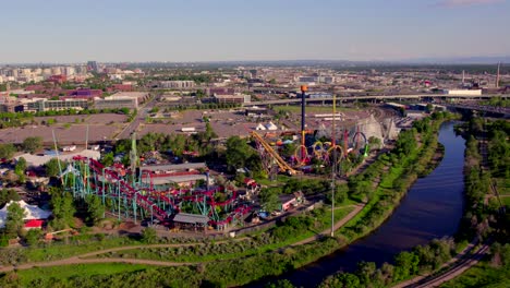 amusement rides at elitch gardens theme park with a view south platte river and cityscape in denver, usa