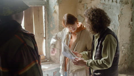 a production worker helping his female coworker read a script in a ruined building 1