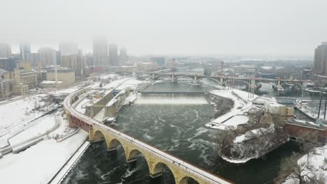 Aerial-Orbiting-Shot-Above-Stone-Arch-Bridge-and-Saint-Anthony-Falls-in-Winter