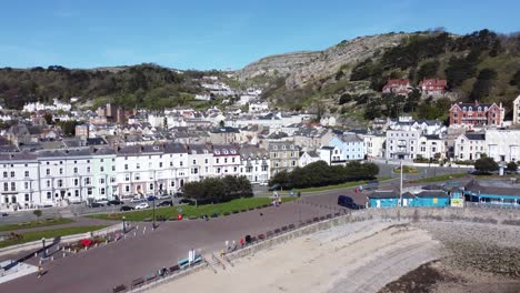 Llandudno-coastal-seaside-town-hotels-on-beachfront-promenade-aerial-view-towards-waterfront