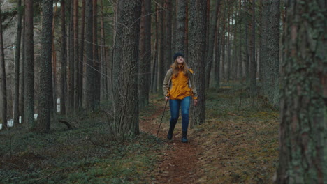 mujer joven caminando en el bosque hacia la cámara