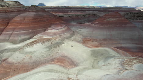 Aerial-View-of-Wioman-Running-Uphill-in-Landscape-Near-Hanksville,-Utah-USA