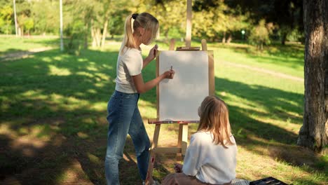 two young women painting outdoors