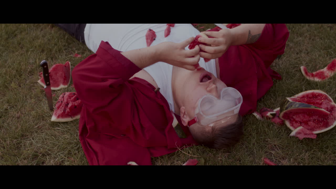 Man Eating Watermelon in Grass