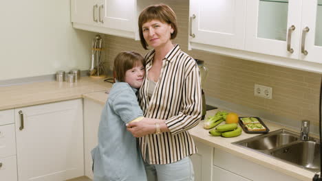 Brunette-mother-kissing-her-daughter-and-she-hugges-her-mother