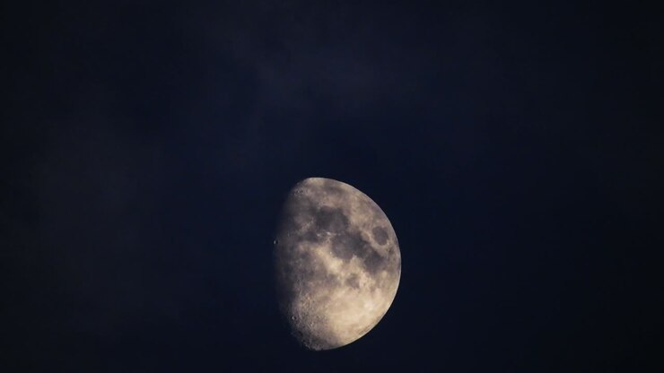Moon at night with cloud real time. 4k video moon in the black sky. Clouds passing by moon at night. night sky with cloudy weather