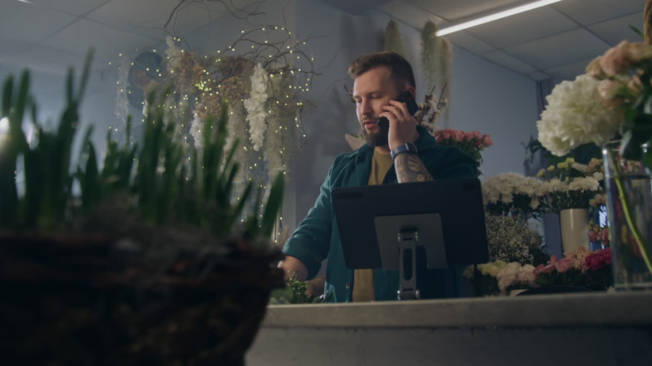 Female Florist Talks By Phone with Customer and Uses Tablet