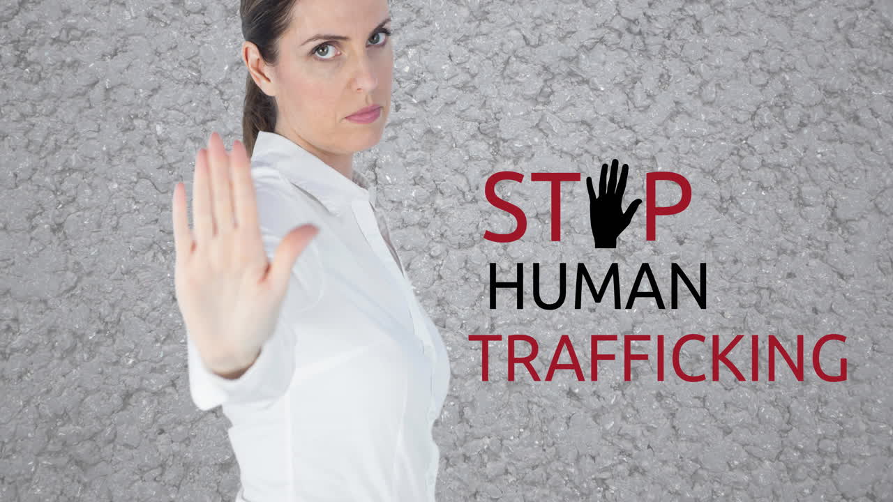 Animation of stop human trafficking text over caucasian woman with stop gesture