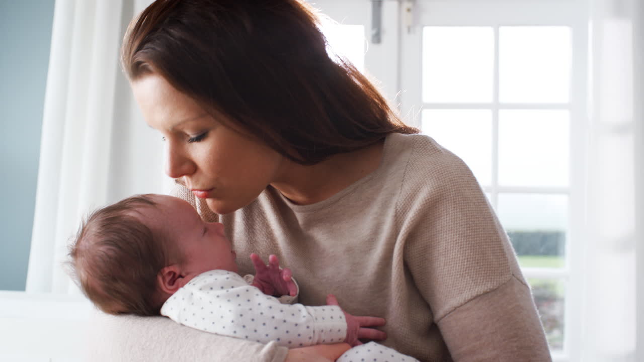 madre amorosa acurrucada durmiendo bebé recién nacido en casa
