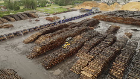 Wooden-logs-stacked-neatly-at-lumberyard-in-Braskereidfoss,-Norway