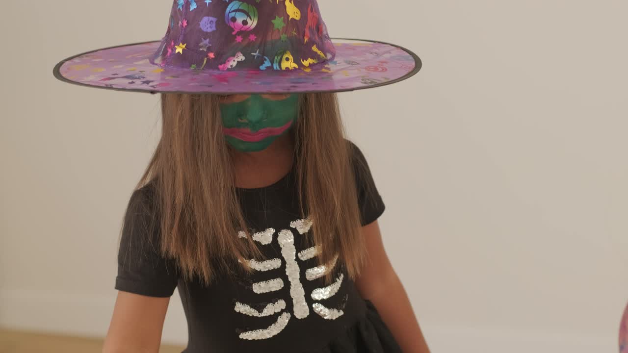 niña con disfraz de bruja jugando con su madre embarazada en halloween