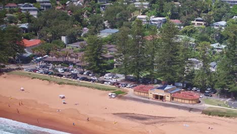 aerial over the sand at palm beach and showing the beach buildings and life saving gear