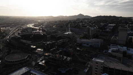 Inclinación-Aérea-Hacia-Abajo-Del-Horizonte-De-El-Paso-Al-Atardecer-Con-Edificios-Y-Montañas