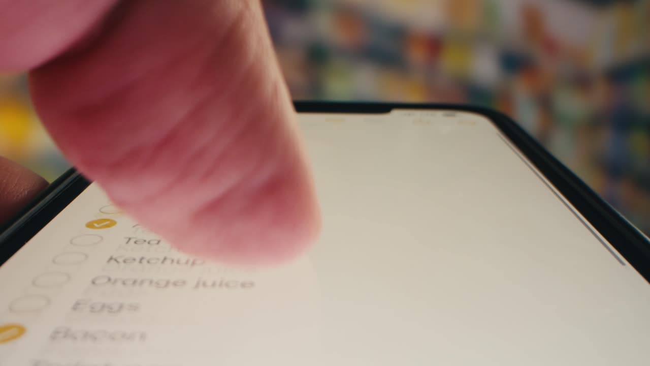 Hand Scrolling and Checking Digital Shopping List on Smartphone Screen
