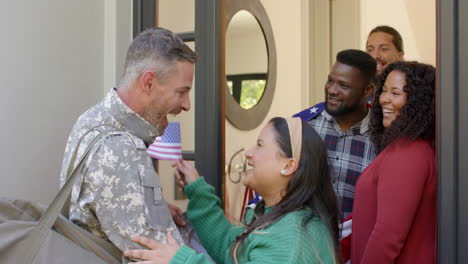 happy diverse friends with flags welcoming home male soldier friend