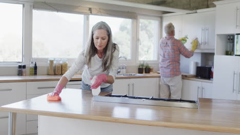 Middle-aged-caucasian-couple-cleaning-kitchen-at-home,-slow-motion