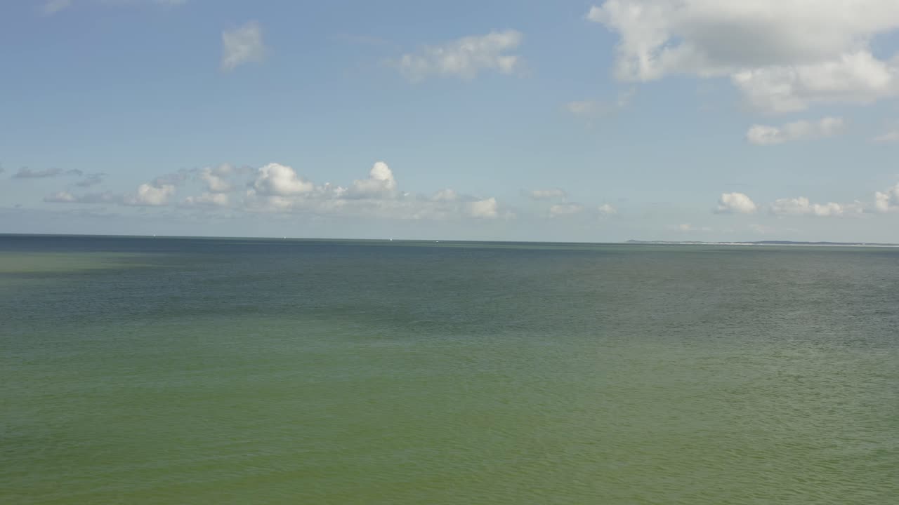 화창한 날 바다 위로 뒤로 날아가는 공중 샷