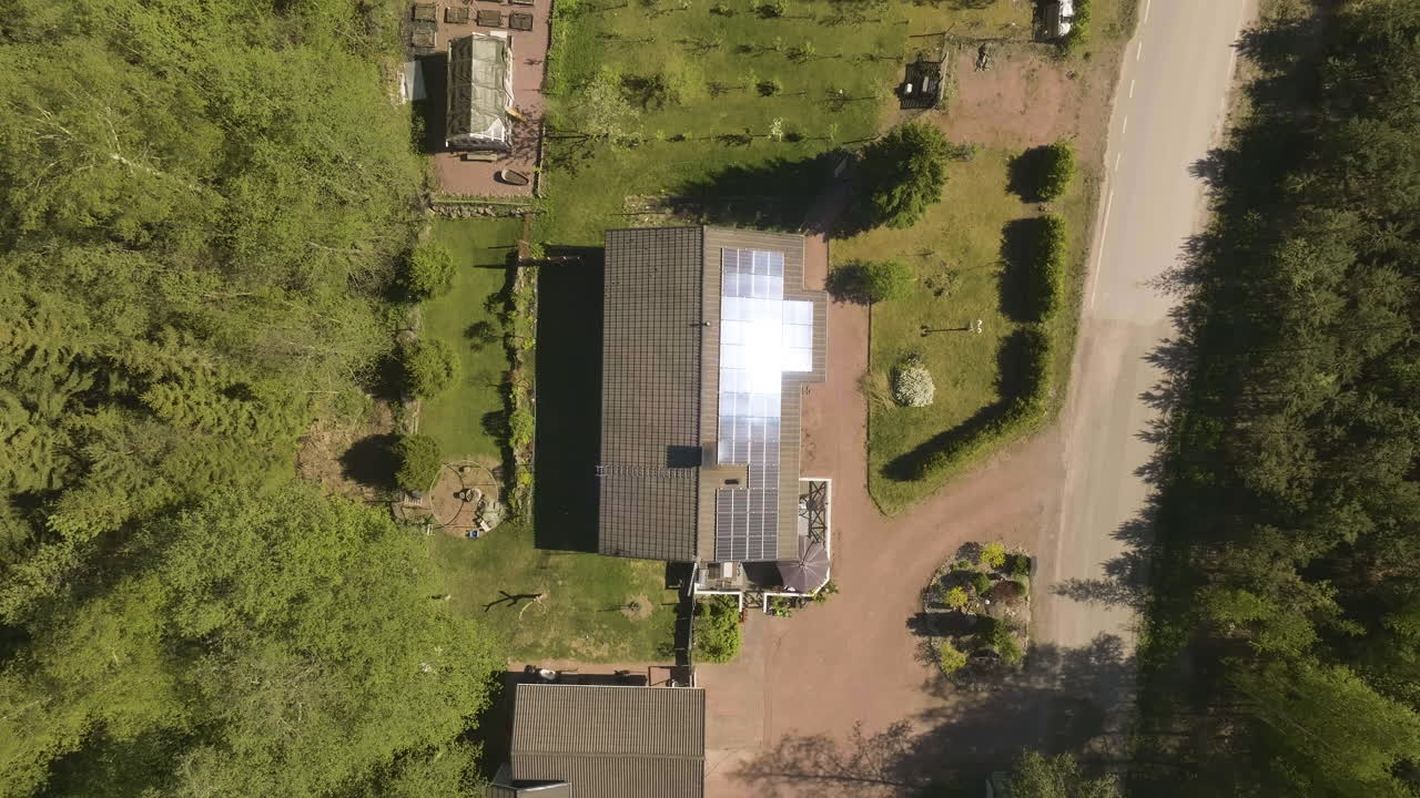 Top down drone shot over reflectiing sunlight collectors on a private house roof