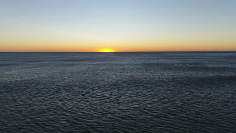 vista aérea de la salida del sol en el horizonte sobre un océano tranquilo en movimiento, en el popular burleigh heads gold coast qld australia