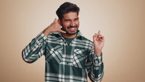 Bearded-indian-man-looking-at-camera-doing-phone-gesture-like-says-hey-you-call-me-back-conversation