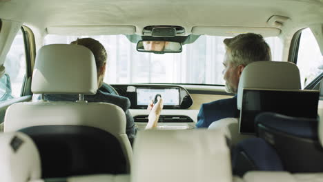 two men discussing car purchase in car dealership