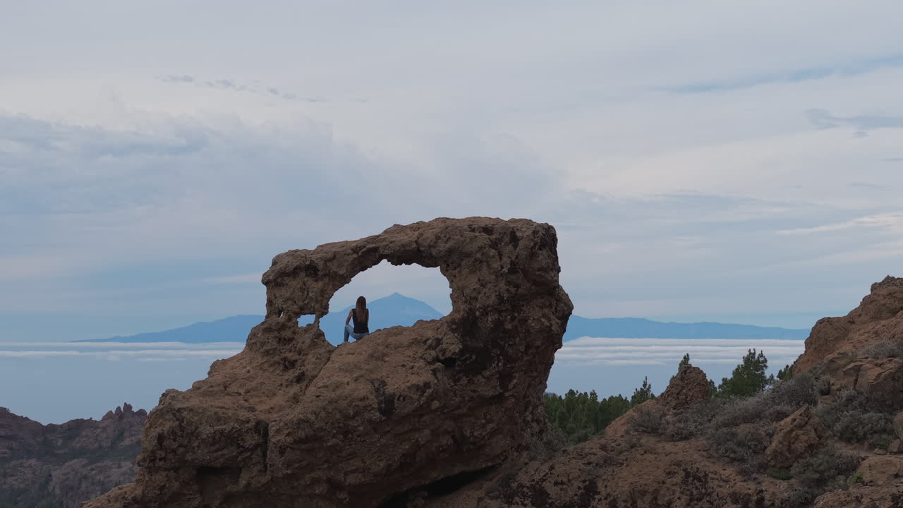 Teide from the Window of Roque Nublo (Gañifa):
Cinematic shot with a woman in the foreground and Mount Teide on the horizon. Gran Canaria.