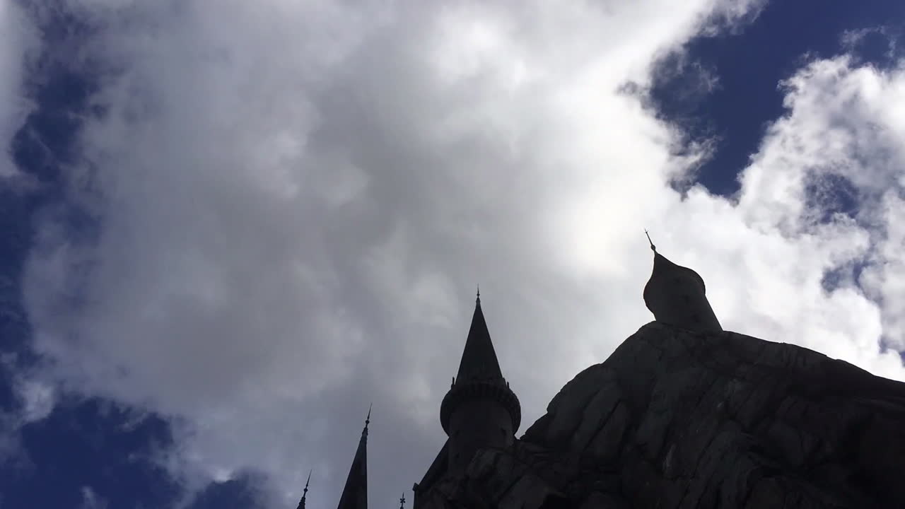 Timelapse clouds moving above a castle on a sunny day.