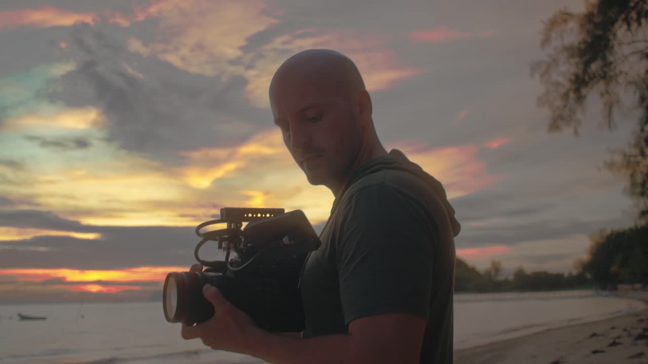 Videomaker che riprende il tramonto in spiaggia