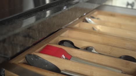 grabbing a utensil out of a kitchen drawer