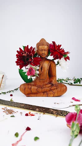 wooden buddha statue with flowers