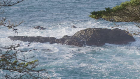 Toma-Estacionaria-Desde-Arriba-De-Las-Olas-Rompiendo-A-Lo-Largo-De-Una-Isla-Rocosa-En-Una-Playa-De-Big-Sur-California