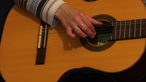 Close-up-girl-practicing-guitar-on-the-bed