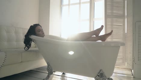 pretty young lady with long legs rests in retro bath