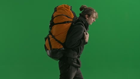 man with a large backpack on a green screen