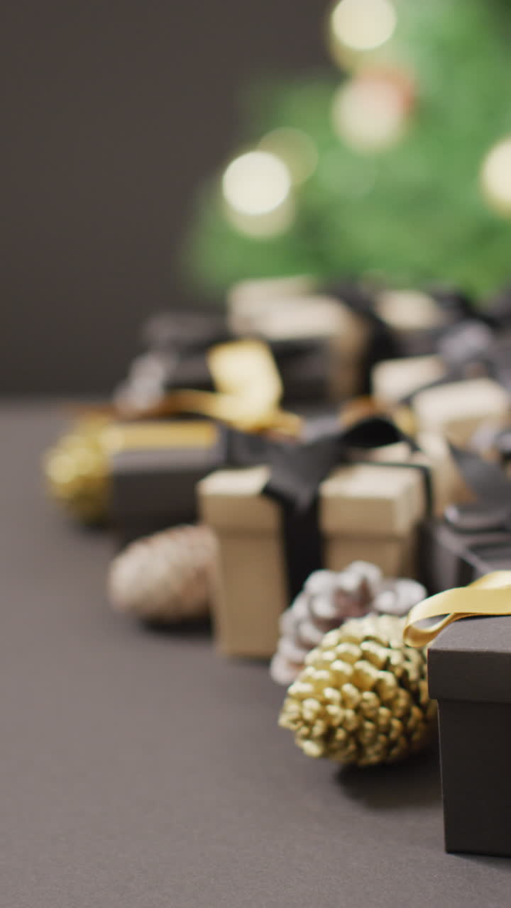 회색 배경 에 있는 크리스마스 선물 과 소나무 어리 의 수직 비디오