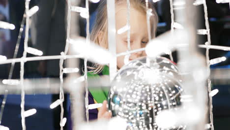 niño jugando con una gran pelota de navidad