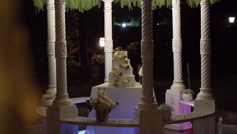 nighttime wedding setting with ornate pillars and elegant cake