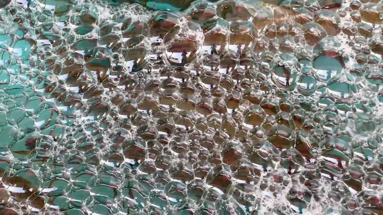 burbujas espumosas flotando en la superficie turquesa del mar