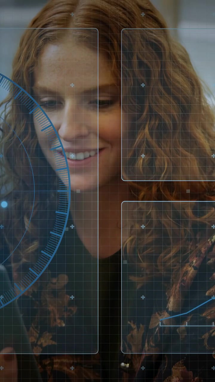 Video verticale: Donna che guarda in basso, poi alza lo sguardo, sorride e ride dopo un'indicazione HUD tecnologica