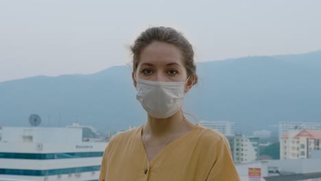woman wearing a mask on a rooftop balcony