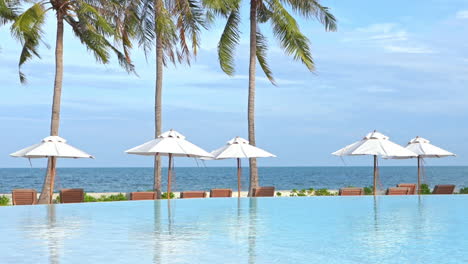 sea view resort with infinity pool and white sun umbrellas