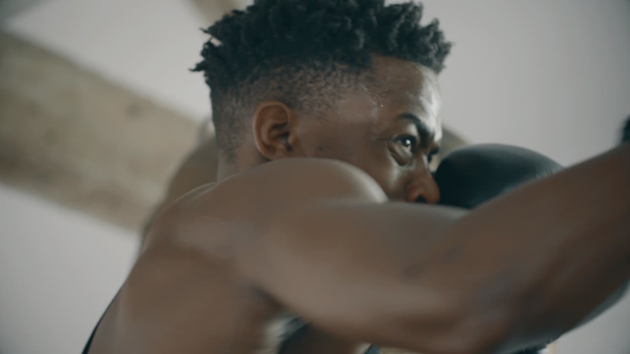 hombre en cámara lenta golpeando saco de boxeo