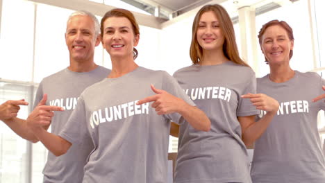 group of volunteers pointing at shirts