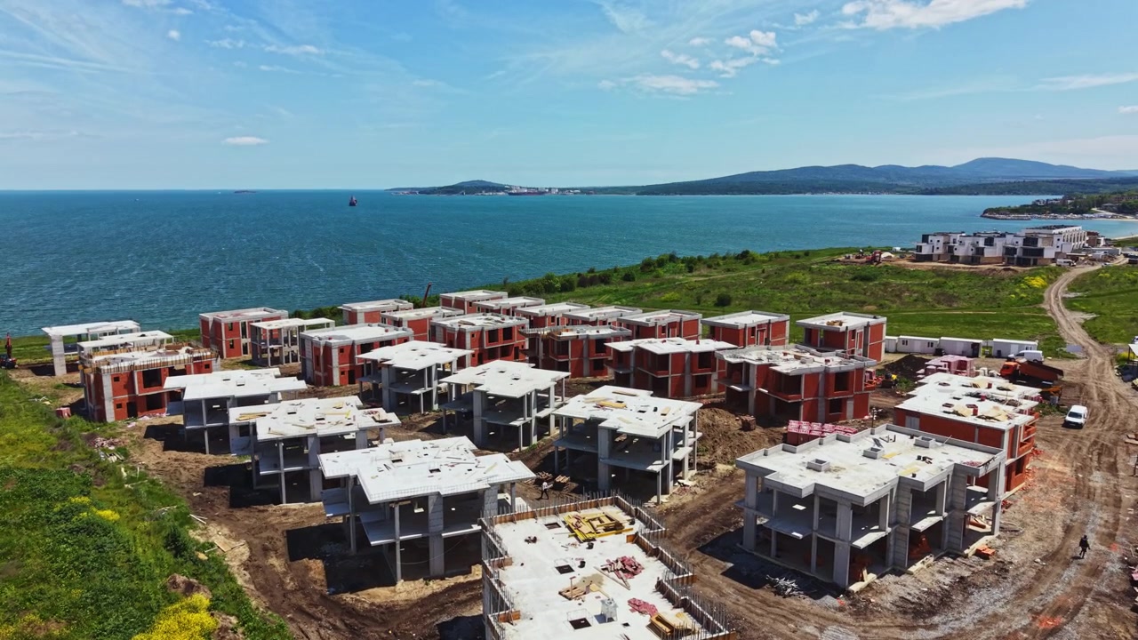Edificazione di nuove abitazioni in prossimità del litorale con vista mare in una giornata di sole, in un'area costiera di un progetto immobiliare in fase di sviluppo.