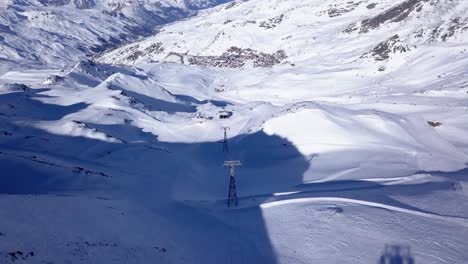 Flying-over-the-gondola-cables-in-Val-Thorens,-in-the-French-Alps